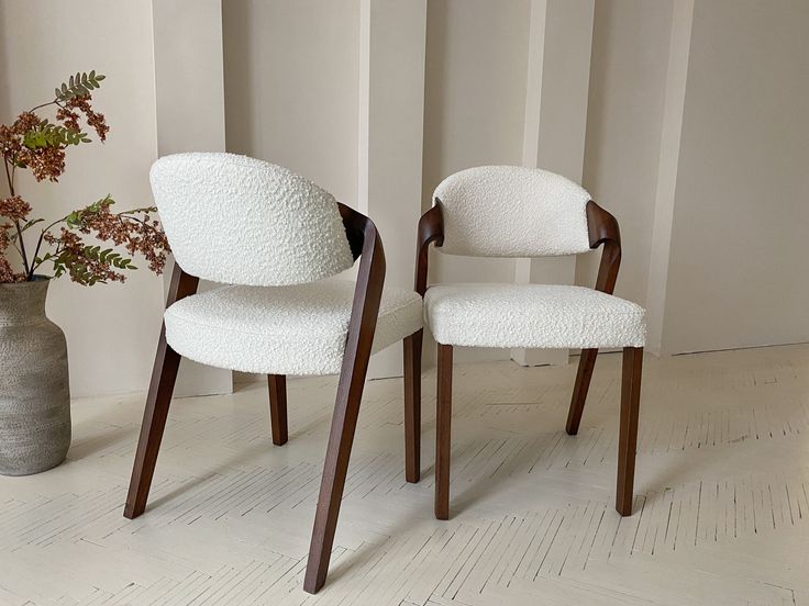 two white chairs sitting next to each other