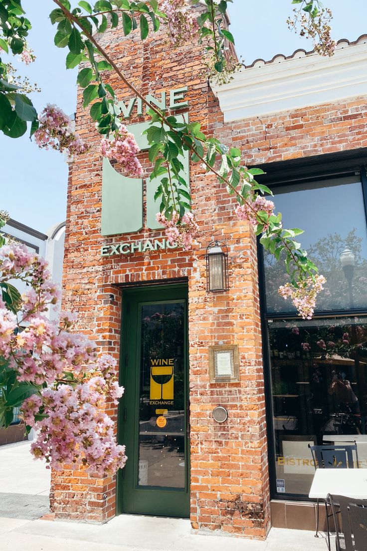 a brick building with pink flowers on the outside