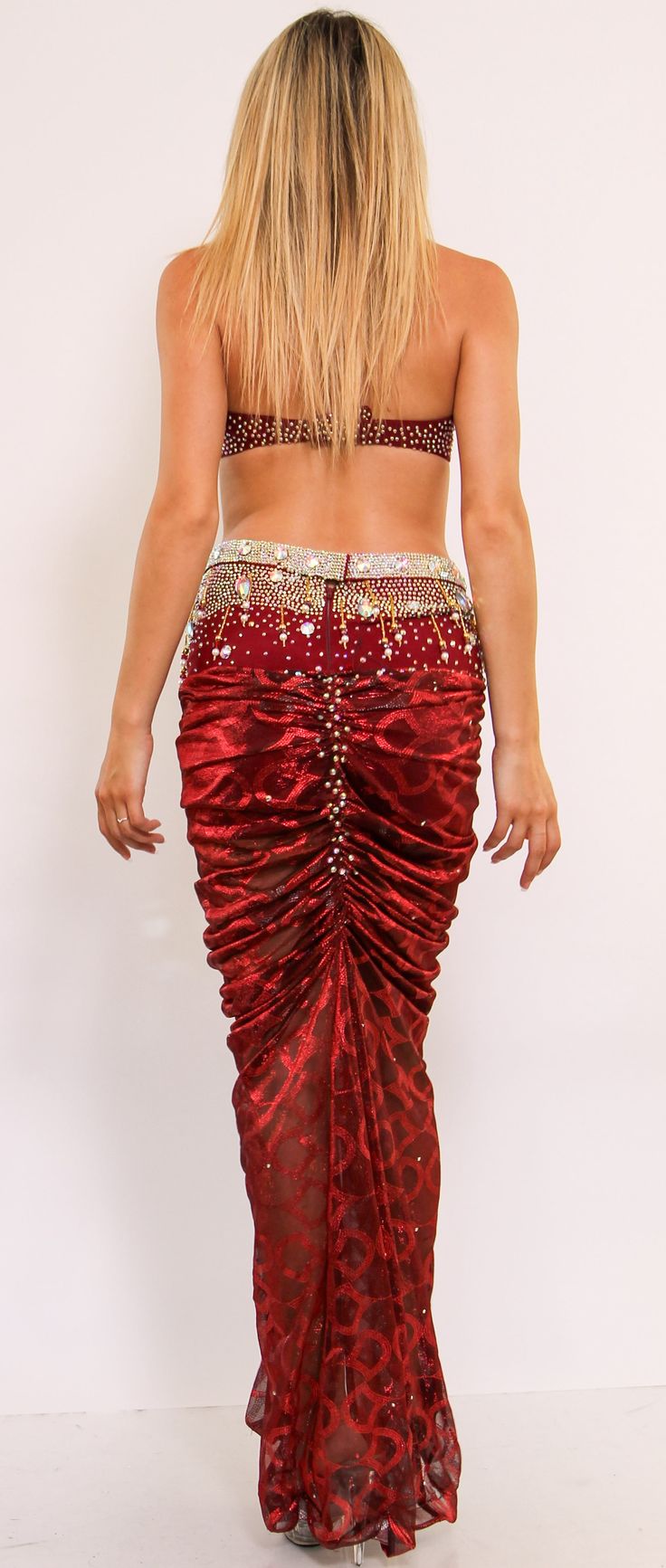 This show-stopping two-piece set showcases beautiful embellishments such as rhinestones, beads, and embroidery in a majestic shade of Burgundy. This two-piece costume features a dina halter bra, and built-in shorts with embellished dazzling crystals. Length is from the top of the skirt. Glamorous Fitted Embellished Sets, Embellished Fitted Traditional Sets, Elegant Fitted Sets With Rhinestones, Elegant Fitted Set With Rhinestones, Glamorous Red Sequined Sets, Fitted Embellished Sets With Traditional Drape, Embellished Fitted Sets With Traditional Drape, Fitted Evening Sets With Rhinestones, Fitted Belly Dance Sets For Party