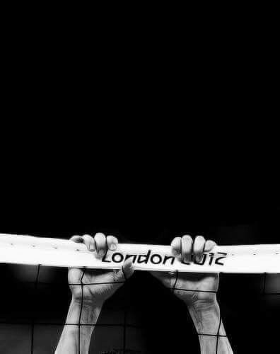 two hands holding up a white surfboard with the word london written on it in front of a black background