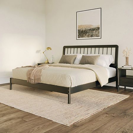 a large bed sitting on top of a wooden floor next to a dresser and lamp