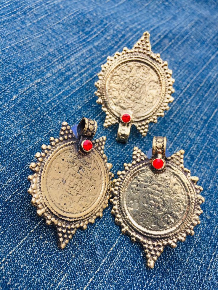 * This complete vintage coin set includes a necklace, a pair of earrings, and a ring, is an epitome of tradition, as the design of the set is inspired by the Afghani Kuchi ornaments. The rusty gold toned set is embellished with dangling elements, adorned with intricate patterns and archaic motifs. The pair of earrings, coin shaped, complete the set in an astonishing manner, complimented by the antique ring in the identical design. You can pair this complete traditional set with any traditional o Brass Coin Pendant Jewelry, Vintage Metal Coin Pendant Necklace, Brass Amulet Jewelry With Coin Pendant, Silver Brass Amulet Coin Necklace, Brass Amulet With Coin Pendant, Brass Coin Pendant Amulet, Brass Amulet Pendant Coin Necklace, Brass Amulet Coin Necklace Pendant, Brass Amulet Coin Necklace With Pendant