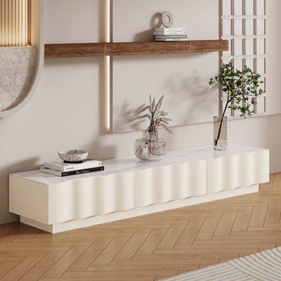 a living room filled with furniture and a plant on top of a white shelf next to a mirror