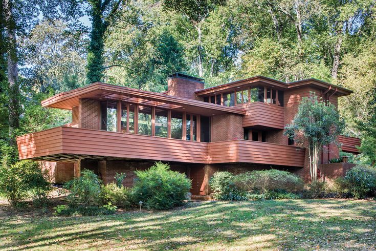 a large brown house surrounded by trees in the woods