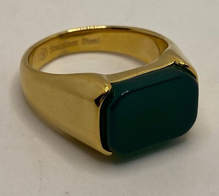 a gold ring with a green stone on it