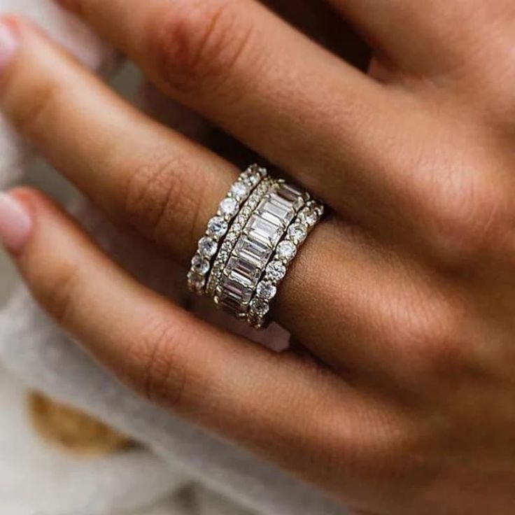 a woman's hand with two rings on her finger and one ring in the middle