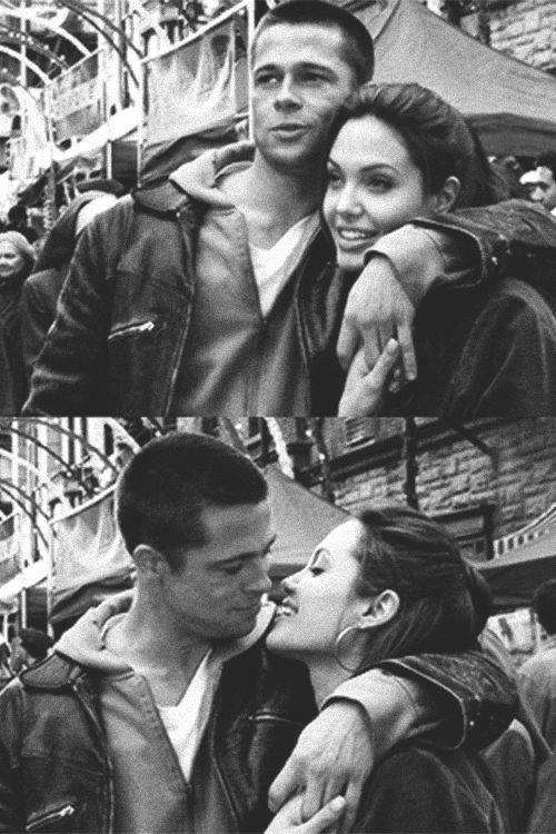 two people kissing each other in front of an amusement park