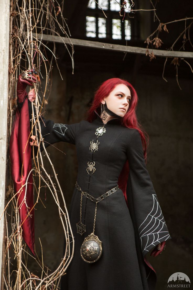 a woman with red hair wearing a black dress and holding a chain around her neck