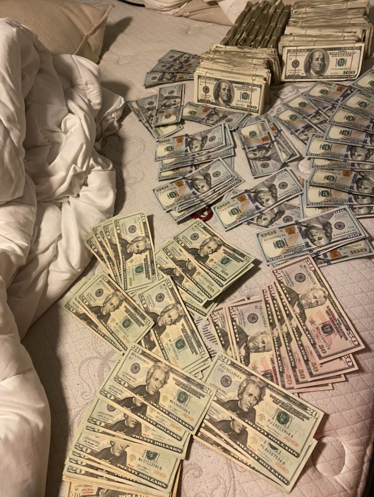 a bed with lots of money laying on top of it