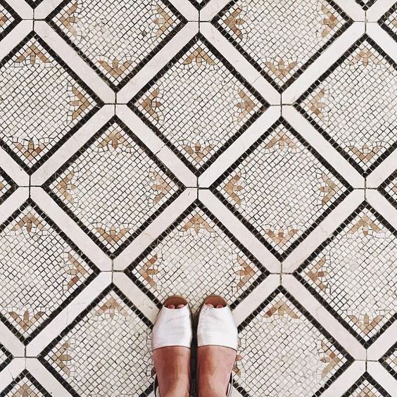 a pair of shoes sitting on top of a tiled floor