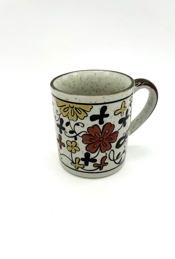 a coffee cup with flowers painted on the outside and inside, sitting on a white surface