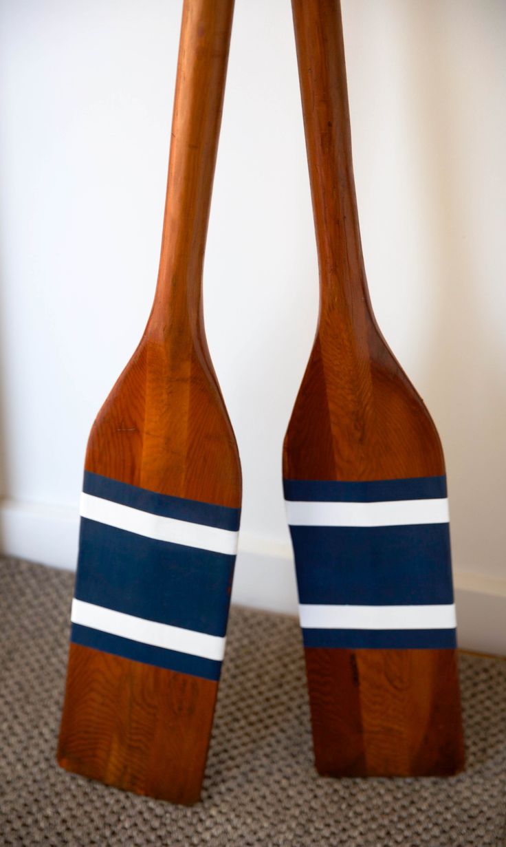 two wooden paddles with blue and white stripes on them sitting next to each other