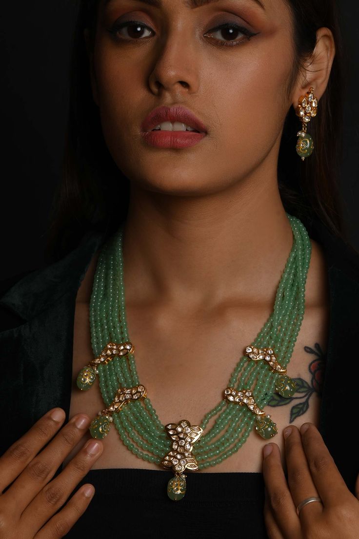 Gold toned layered choker necklace with light green beads and stones embellishments. Comes with a matching pair of earrings.
Components: 1 Necklace, Pair of earrings
Type: Beads, Stones
Composition: Silver alloy
Color: Green
Other Details: 
Necklace Length (in inches): 24
Product Weight (in gms): 100
Closure:
Necklace: Thread
Earrings: Push pin
Disclaimer: Each piece is handmade and very intricately done. Every accessory may contain semi precious stones, pearls and swarovski crystals that may va Green Necklaces With Dangling Beads For Celebration, Green Dangling Beads Necklace For Celebration, Festive Green Gemstone Beaded Necklace, Green Polished Beads Jewelry For Party, Festive Green Gemstone Bead Necklaces, Festive Green Faceted Beads Necklace, Festive Green Gemstone Beads Necklace, Festive Green Beads, Green Beaded Necklaces With Dangling Beads For Party