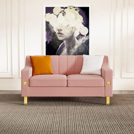 a living room with a pink couch and white flowers on the wall above it in front of a painting