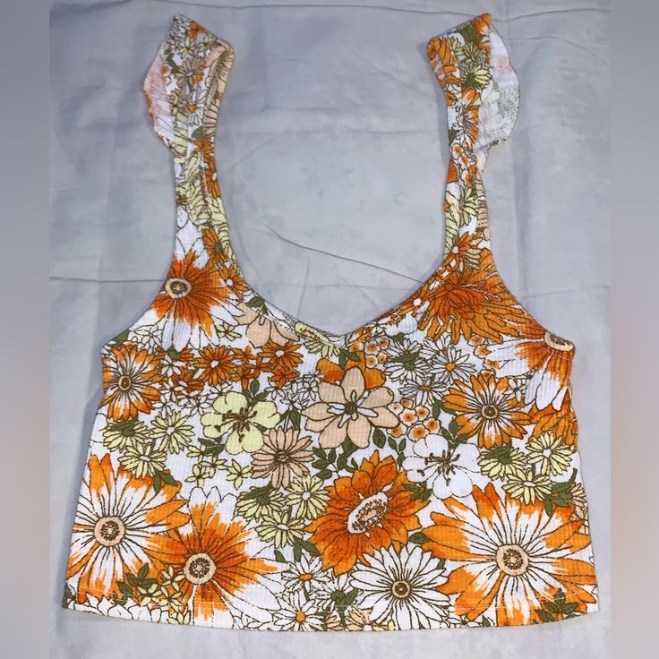 Size Small Floral With Ruffles On Sleeves Never Worn Summer Floral Print Crop Top For Beach Season, Floral Print Crop Top For Beach Season, Summer Printed Crop Top, White Floral Print Summer Crop Top, White Sleeveless Retro Crop Top, Urban Outfitters Cotton Tops With Floral Print, White Retro Crop Top For Summer, Retro White Crop Top For Summer, White Floral Print Crop Top For Day Out