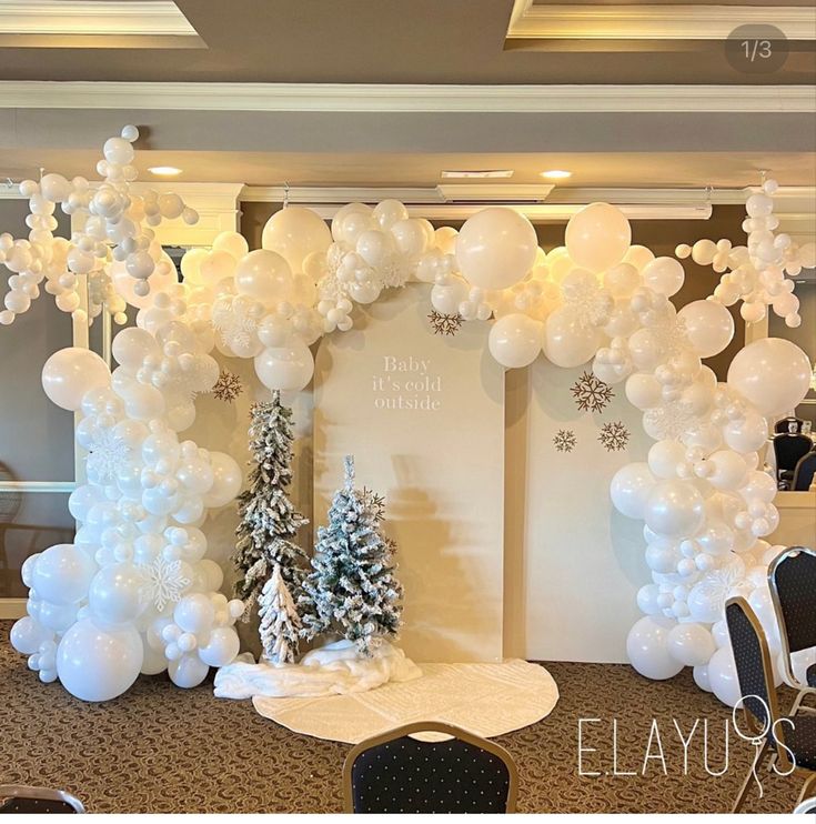 an arch made out of balloons with trees and snowflakes on the top is decorated for christmas