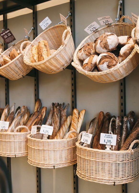 breads and pastries are displayed in baskets on display