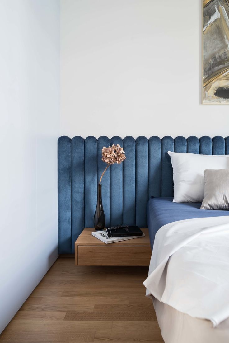 a blue headboard in the corner of a bedroom