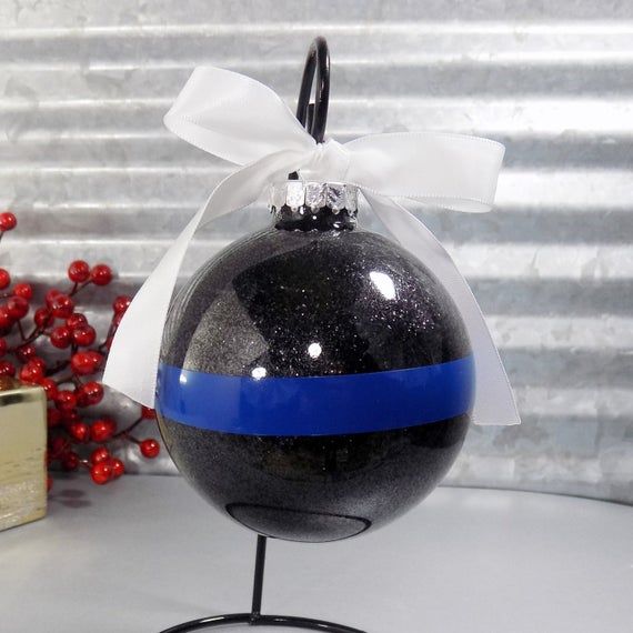 a black and blue ornament with a white ribbon