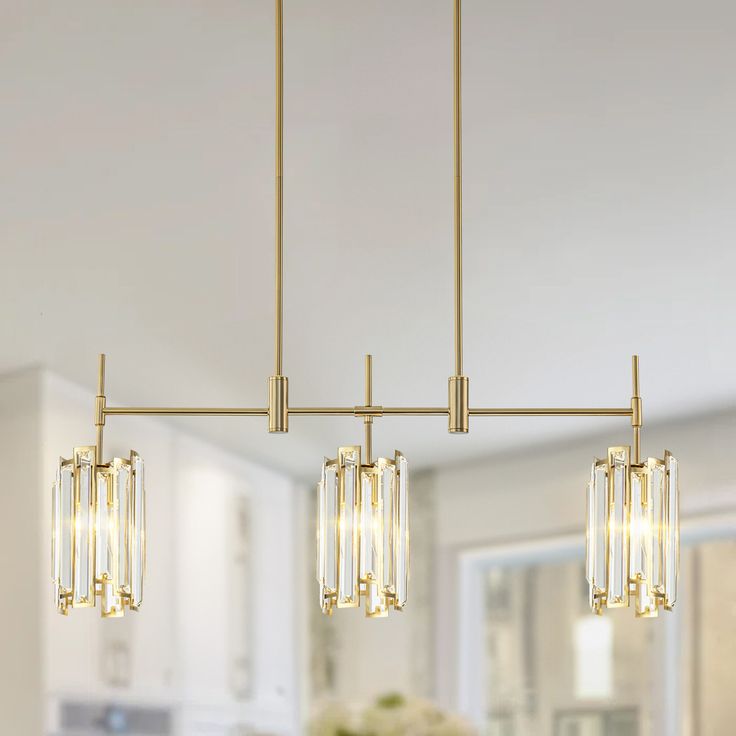 three lights hanging over a kitchen island in a room with white walls and flooring