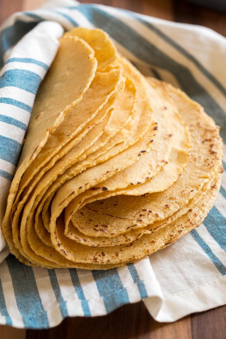 a stack of tortillas sitting on top of a blue and white towel