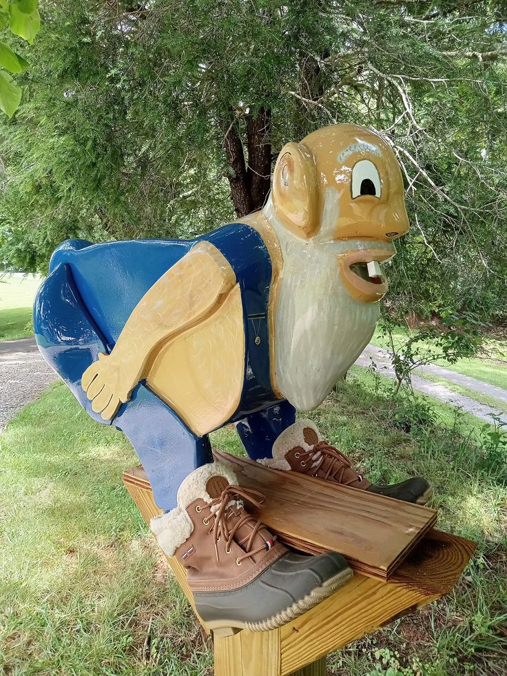 a statue of a gnome sitting on top of a wooden bench