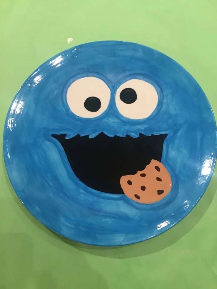 a blue plate with a cookie on it that looks like an evil looking monster's face