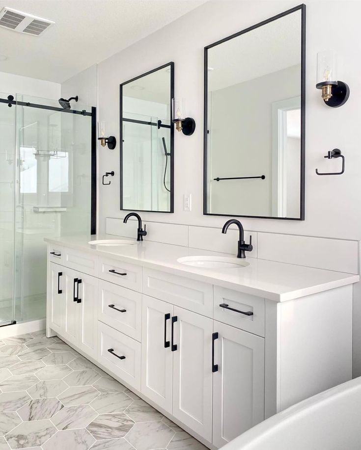 a white bathroom with double sinks and mirrors