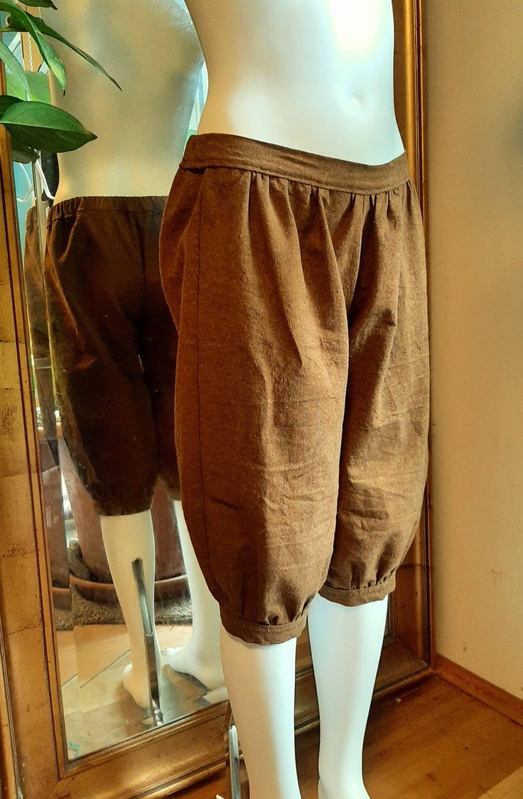 "(All sizes will be available soon, these are a new item - better photos to come as well if it ever stops raining) These historic style breeches are made of cinnamon brown yarn dyed linen. They are below knee length, they are loose fitted with a cuff at the hem. The waistband is flat in front with gathers below it and there is elastic at the back for comfort and easy fitting. These are a great basic style that works well with renaissance or medieval outfits, pirate costumes, colonial era costume Fitted Knee-length Linen Bottoms, Fitted Linen Knee-length Bottoms, Brown Cotton Knee-length Bottoms, Brown Knee-length Bottoms For Summer, Brown Knee-length Summer Bottoms, Brown Cotton Knee-length Shorts, Fall Cotton Knee-length Pants, Brown Cotton Shorts For Fall, Knee-length Cotton Pants With Elastic Waistband