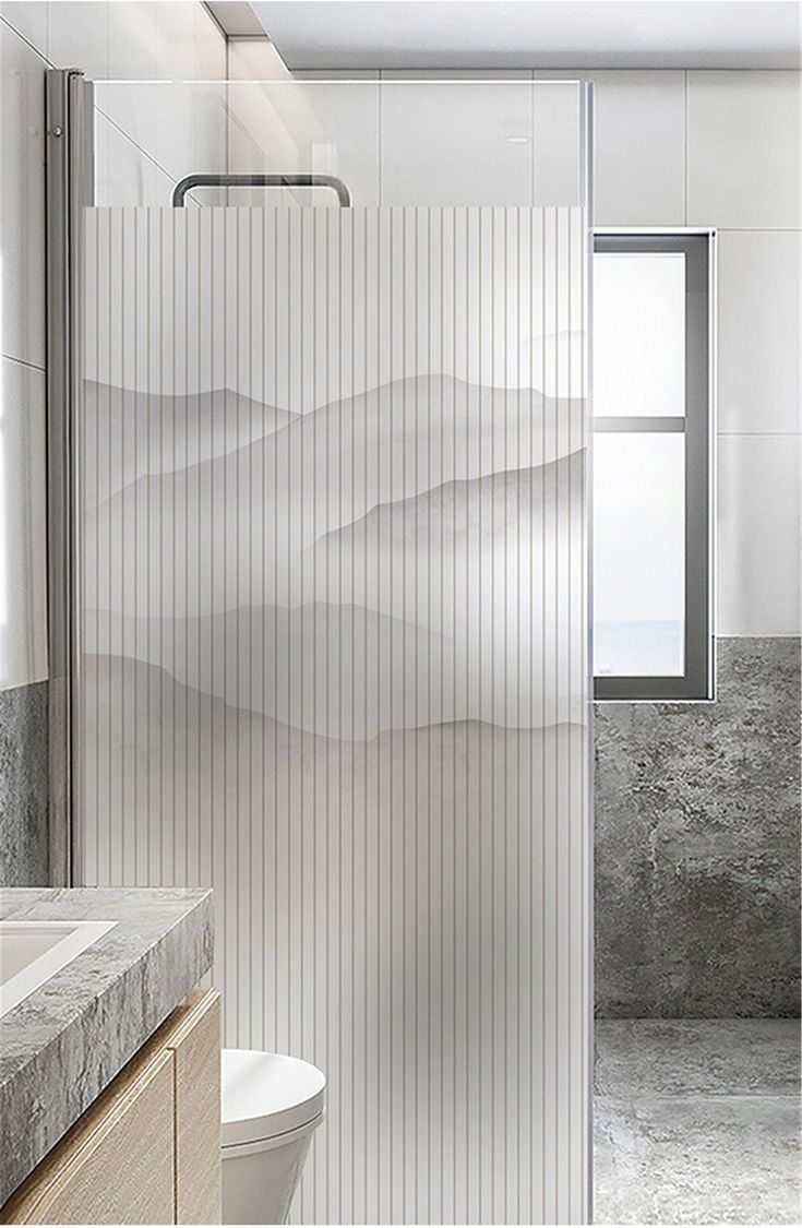 a bathroom with a glass shower door and marble counter top, along with a white toilet