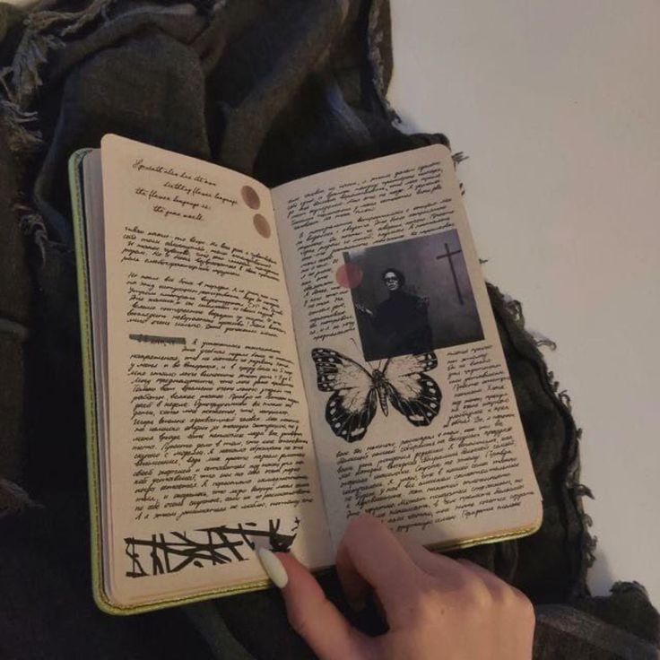 a person holding an open book in their left hand and touching it with the other hand