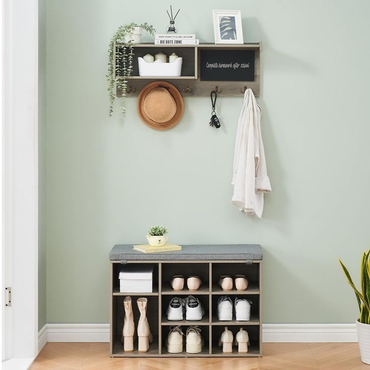 an entryway with shelves, potted plants and other items on the wall next to it