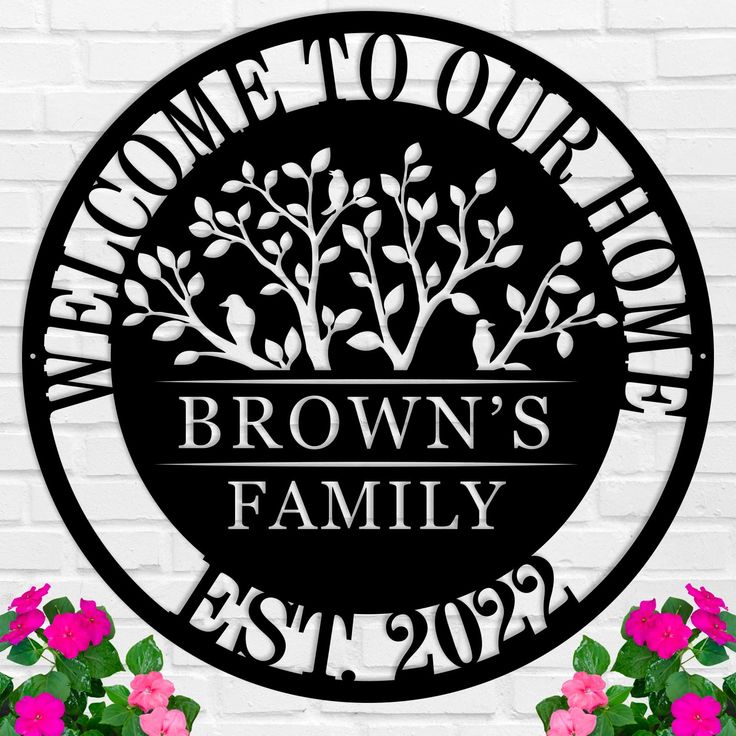 a metal sign that says welcome to our brown's family with flowers in front of it