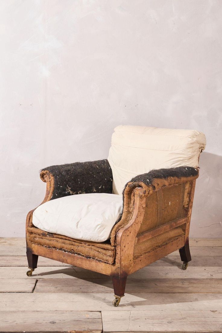 an old wooden chair with a white pillow on it