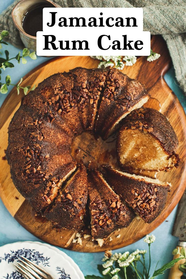 a close up of a cake on a wooden platter with the words jamaican rum cake above it