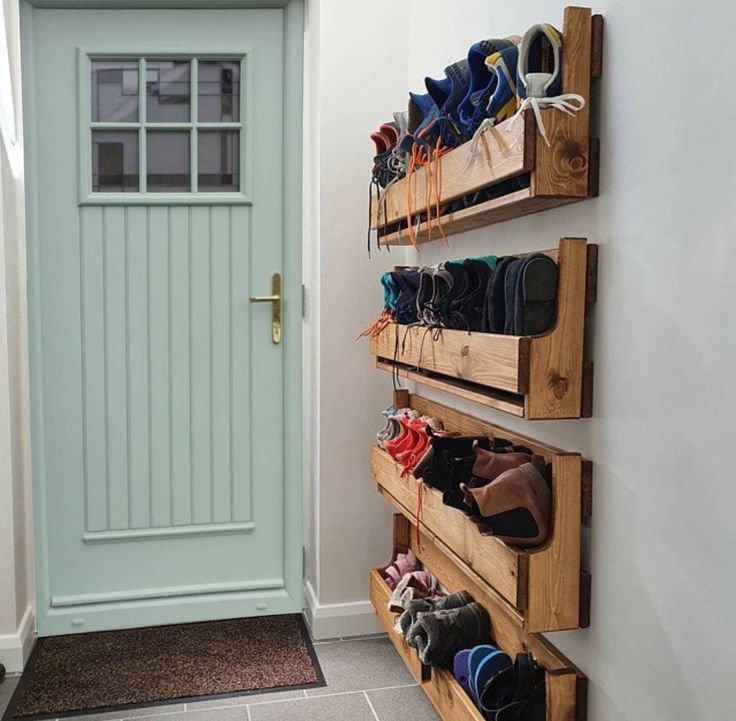 there are many pairs of shoes hanging on the wall next to the door in this hallway