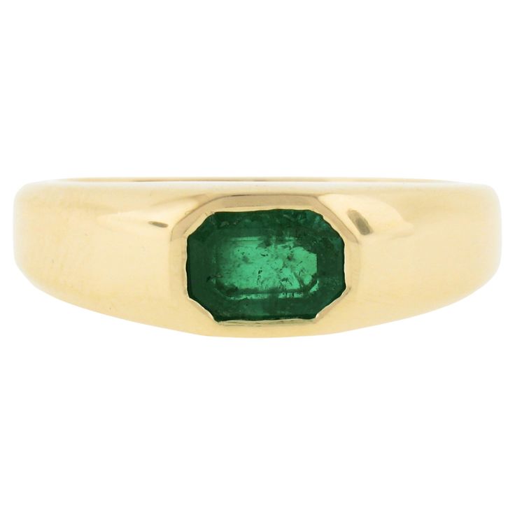 a gold ring with an emerald stone in the center