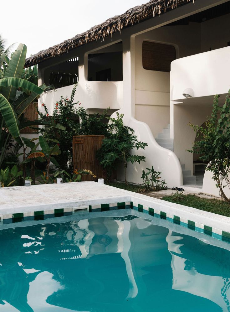 an empty swimming pool in front of a house