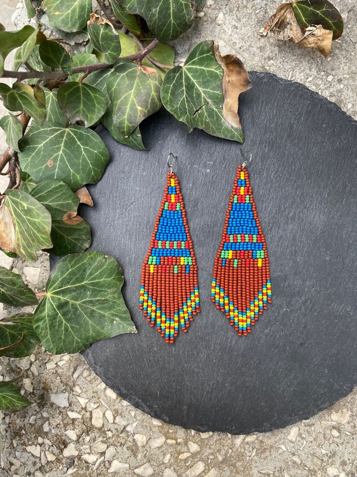 Brown blue woven earrings, abstract seed beaded earrings, fringe small earrings, Triangle Bohemian, festival earrings, Boho earrings Hippie ♥𝑇ℎ𝑒 𝑝𝑎𝑡𝑡𝑒𝑟𝑛 𝑜𝑓 𝑡ℎ𝑖𝑠 𝑒𝑎𝑟𝑟𝑖𝑛𝑔 𝑖𝑠 𝑐𝑟𝑒𝑎𝑡𝑒𝑑 𝑏𝑦 𝐾𝑎𝑍𝑒𝐵𝑒𝑎𝑑𝐽𝑒𝑤𝑒𝑙𝑟𝑦 ♥𝑀𝑎𝑑𝑒 𝑢𝑠𝑖𝑛𝑔 𝑓𝑟𝑒𝑒ℎ𝑎𝑛𝑑 𝑏𝑒𝑎𝑑𝑖𝑛𝑔 𝑤𝑜𝑣𝑒𝑛 𝑡𝑒𝑐ℎ𝑛𝑖𝑞𝑢𝑒𝑠 𝑤𝑖𝑡ℎ 𝑠𝑡𝑟𝑜𝑛𝑔 𝑠𝑦𝑛𝑡ℎ𝑒𝑡𝑖𝑐 𝑡ℎ𝑟𝑒𝑎𝑑. ♥𝑇ℎ𝑒 𝑠𝑖𝑧𝑒 𝑜𝑓 𝑡ℎ𝑒 𝑠𝑒𝑒𝑑 𝑏𝑒𝑎𝑑𝑠 𝑢𝑠𝑒𝑑 𝑖𝑠 2 𝑚𝑖𝑙𝑙𝑖𝑚𝑒𝑡𝑒𝑟𝑠 𝑎𝑛𝑑 𝑏𝑒𝑎𝑑𝑠 𝑎𝑟𝑒 ℎ𝑖𝑔ℎ 𝑞𝑢𝑎𝑙𝑖𝑓𝑖𝑒𝑑. ♥𝐴𝑙𝑙 𝑡ℎ𝑒 ℎ𝑜𝑜𝑘𝑠 𝑢𝑠𝑒𝑑 𝑖𝑛 𝑜𝑢𝑟 𝑗𝑒𝑤𝑒𝑙𝑟𝑦 𝑎𝑟𝑒 24 𝑘 𝑔𝑜𝑙𝑑 𝑝𝑙𝑎𝑡𝑒𝑑 𝑎𝑛𝑑 ℎ𝑦𝑝𝑜𝑎𝑙𝑙𝑒𝑟𝑔𝑒𝑛𝑖𝑐. ♥𝑇ℎ𝑒𝑠𝑒 𝑎𝑟𝑒 𝑣𝑒𝑟𝑦 𝑙𝑖𝑔ℎ𝑡 𝑒𝑎𝑟𝑟𝑖𝑛𝑔𝑠 𝑡ℎ𝑎𝑡 𝑦𝑜𝑢 𝑐𝑎𝑛 𝑤𝑒𝑎𝑟 𝑎𝑙𝑙 𝑑𝑎𝑦 𝑤𝑖𝑡ℎ𝑜𝑢𝑡 ℎ𝑢𝑟𝑡𝑖𝑛𝑔 𝑦𝑜𝑢𝑟 𝑒𝑎𝑟! The on Traditional Beaded Earrings With Fringe For Festivals, Traditional Beaded Fringe Earrings For Festival, Blue Handwoven Beaded Earrings For Festivals, Festival Fringe Earrings With Round Beads, Traditional Fringe Beaded Drop Earrings, Traditional Handwoven Blue Beaded Earrings, Traditional Blue Handwoven Beaded Earrings, Traditional Beaded Fringe Tassel Earrings For Festivals, Blue Fringed Beaded Earrings For Festival