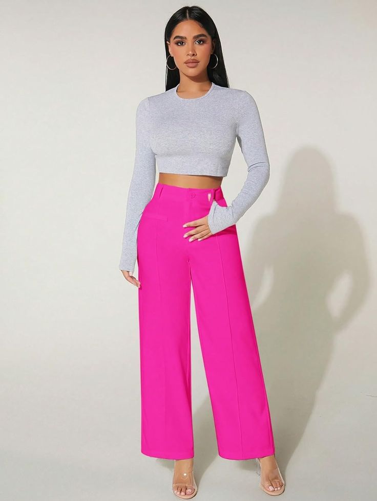 a woman is wearing pink pants and a crop top with her hands on her hips