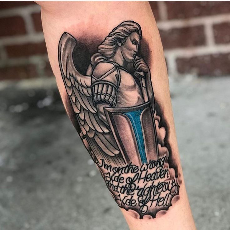 a tattoo on the leg of a woman with an angel holding a cross and bible verse