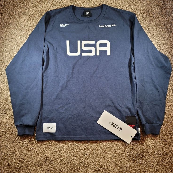 Brand New With Tags, Men's New Balance X Wtaps Tc Jersey Long Sleeve T-Shirt In Size Small. Mt01606 The Shirt Is Navy Blue And White. Measurements (+/- .25"): Top Of Neck To Bottom Hem: 26.75" Shoulder To Shoulder: 20" Pit To Pit: 20.5" Waist: 20" Bottom Hem: 21" Sleeve Length: 33" From Manufacturer's Description: New Balance And Japanese Brand Wtaps Continue Their Partnership This Season, Once Again Spotlighting The Iconic Made In The Us Range. And With This Navy Blue Tee, The References Are Im Blue Letter Print Sportswear Tops, Navy Sporty Shirt With Crew Neck, Navy Sporty Crew Neck Shirt, Sporty Navy Shirt With Crew Neck, Outdoor Sportswear Tops With Letter Print, Sporty Tops With Logo Print For Outdoor, Navy Sporty Outdoor Tops, Navy Crew Neck Top For Streetwear, Navy Sporty Tops For Outdoor