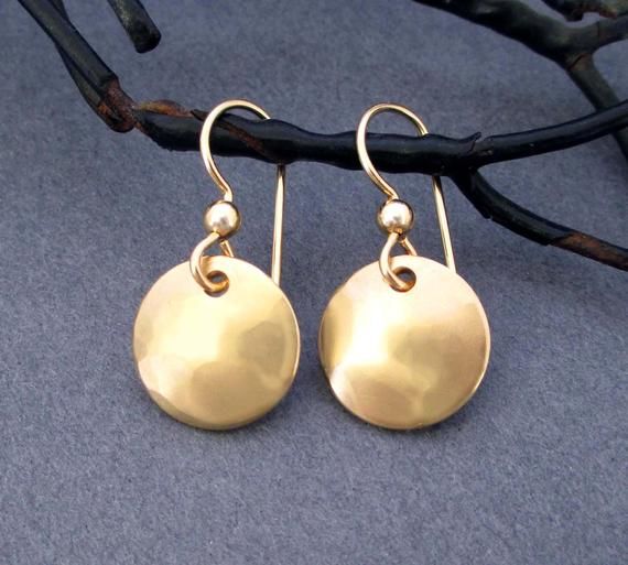 Handmade entirely in 14k gold filled metal, swingy dangles mimic the look and luxury of 14k solid gold, but at a fraction of the price.  These small gold earrings are fun to wear with casual everyday outfits.  Dainty round disc dangles are hand cut from 14k gold filled sheet metal and finished with smooth texture.  Ear wires are handmade in 14k gold filled wire.Earring Dimensions:Width - 1/2 inch across widest point of dangle (12mm)Drop Length - just over 1 inch from top of ear wire to bottom of Simple Yellow Gold Dangle Earrings, Simple Gold Dangle Jewelry, Simple Gold Brass Jewelry, Simple Yellow Gold Nickel-free Jewelry, Gold 14k Round Disc Earrings, Casual Everyday Outfits, Small Gold Earrings, Bronze Anniversary, Copper Jewellery