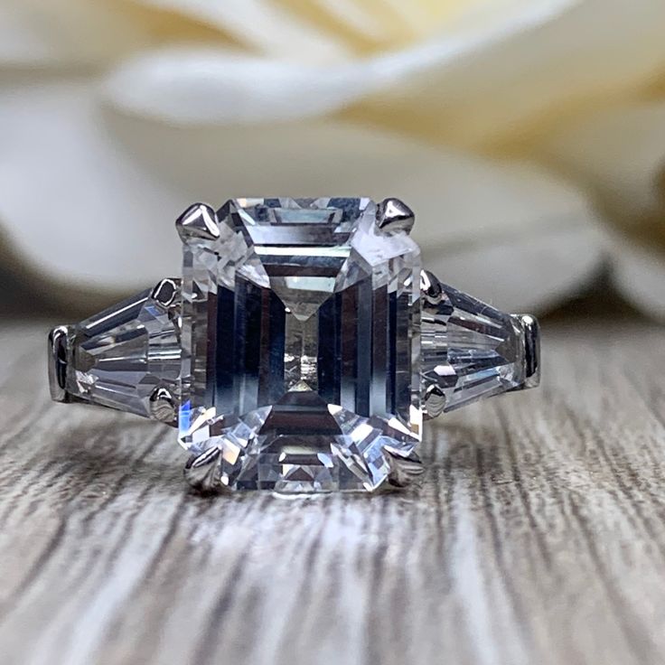 🐕 Big deals! Emerald Cut Moissanite Engagement Ring, Emerald Cut White Sapphire Wedding Ring For Ladies , April Birthstone Ring 14k White Gold, #6660 only at $685.00 Hurry. #MoissaniteRing #6639 #BirthdayGift #InfinityJewelers #AnniversaryGift #AprilBirthstone #6660 #WhiteSapphireRing #EmeraldCut #LadiesWeddingRing Cubic Zirconia Asscher Cut Ring With Accent Stones, Wedding Emerald Ring With Accent Stones In Platinum, Platinum Emerald Ring With Accent Stones For Wedding, Dazzling Emerald Cut Diamond Ring With Accent Stones, Emerald Ring With Diamond And Baguette Cut Cubic Zirconia, Luxury Baguette Cut Diamond Ring With Accent Stones, Gia Certified Platinum Topaz Wedding Ring, Asscher Cut Moissanite Rings With Accent Stones, Baguette Cut Diamond Ring With Accent Stones