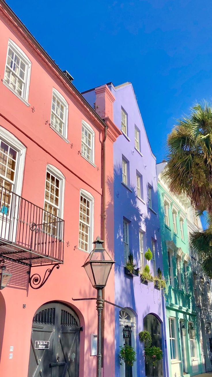 several colorful buildings line the street with palm trees in front of them on a sunny day