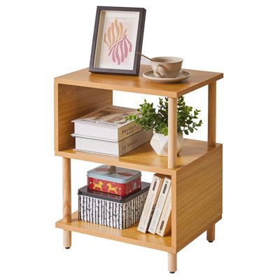 a small wooden shelf with books on it and a potted plant next to it