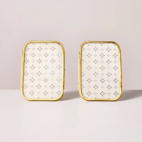 two white and gold square shaped trays sitting on top of a table