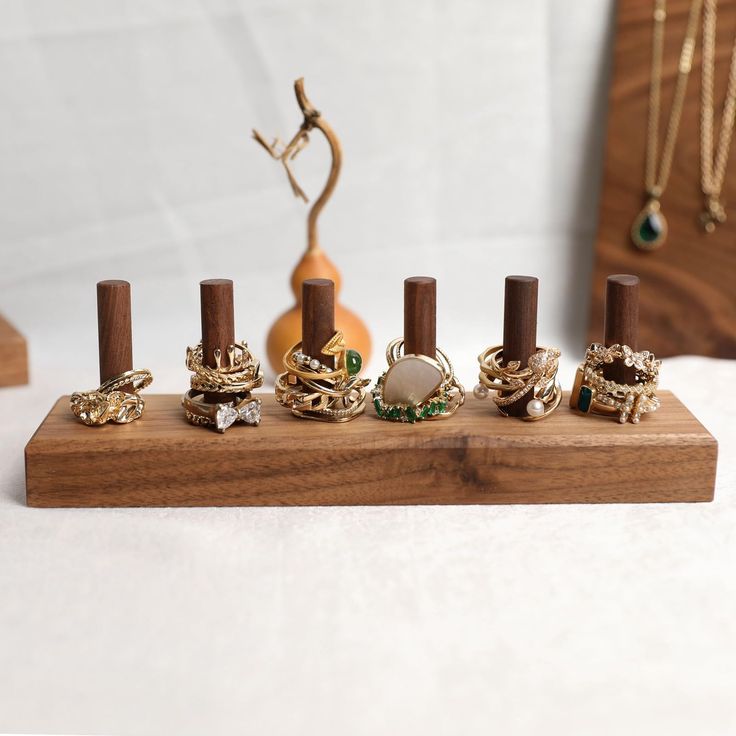 an assortment of rings on a wooden stand