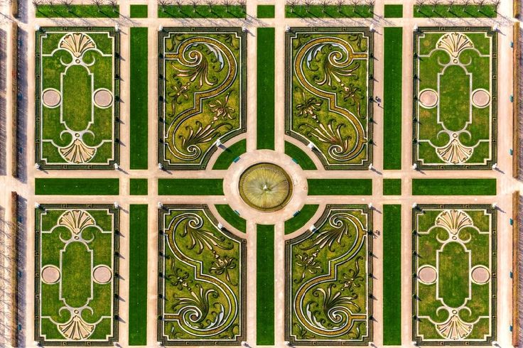 an aerial view of the top of a building with green grass and flowers on it