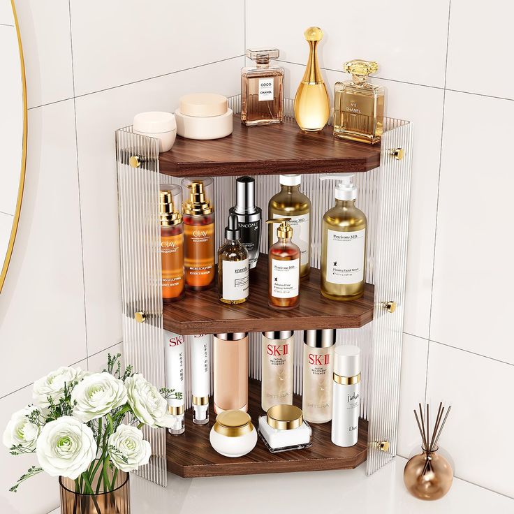 three tiered shelves with bottles and candles on them in a bathroom next to a flower vase